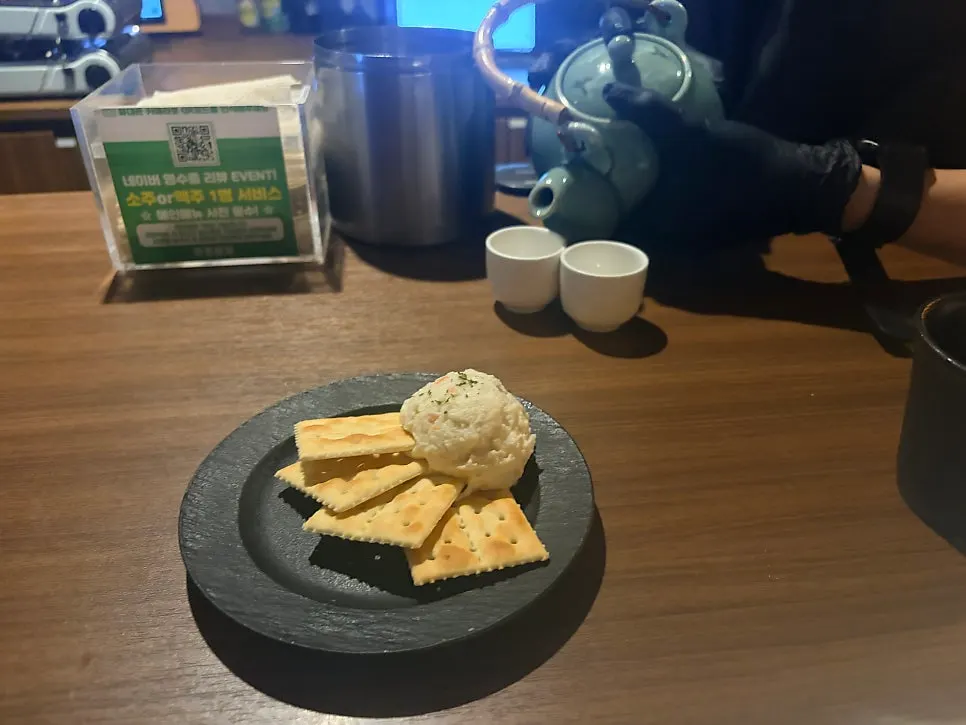 A cracker topped with potato salad, one bite-sized anju