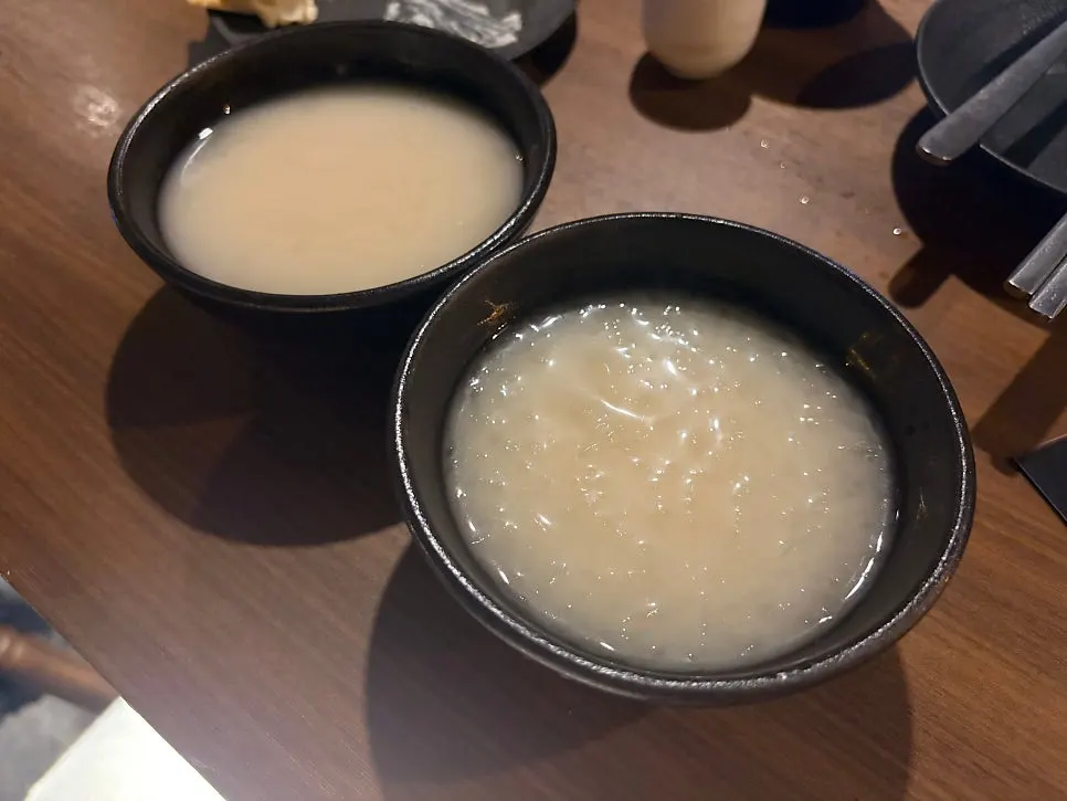 A cup of nurungji dongdongju with anju on the table