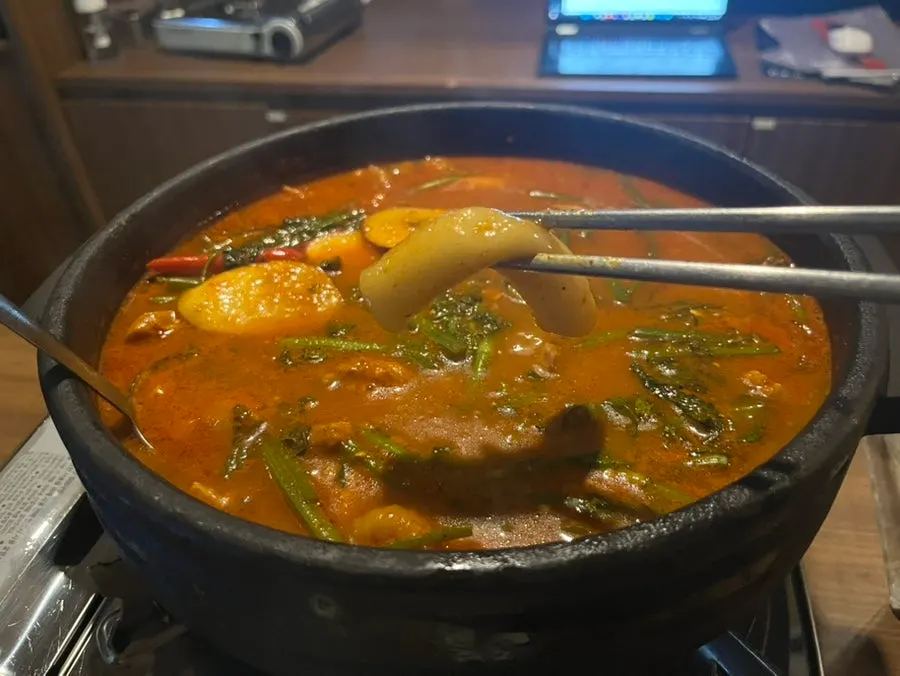 Boneless chicken layered under minari in the mul dakgalbi