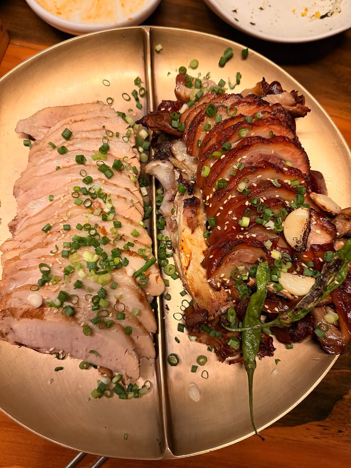 A plate of boneless dakbal topped with scallions and sesame seeds