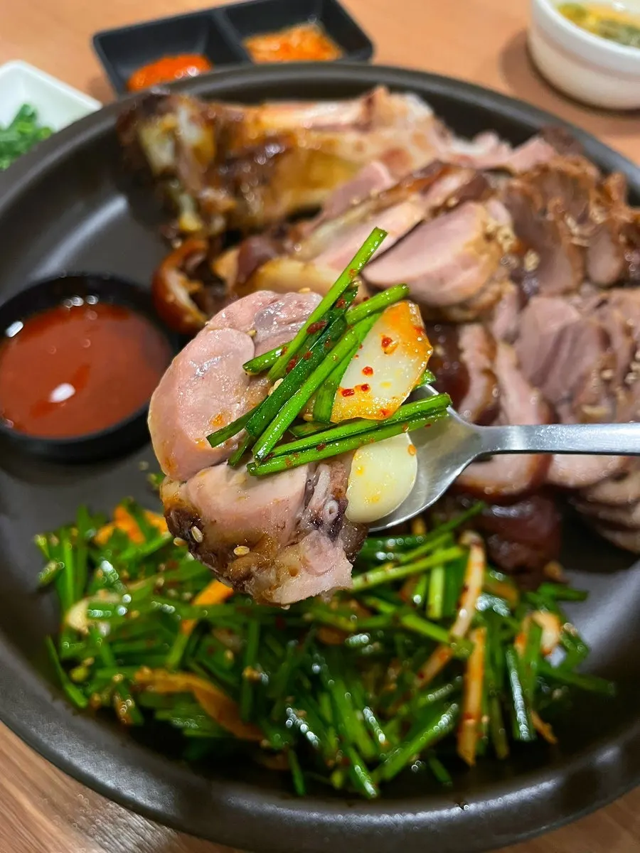 Jokbal topped with garlic chive salad and garlic