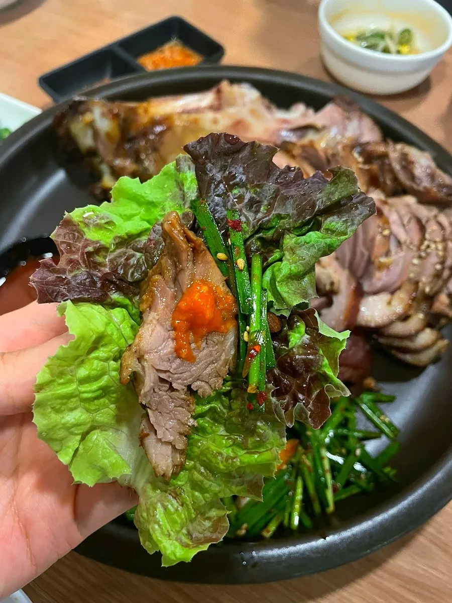 Wrap leaf topped with jokbal and side dishes