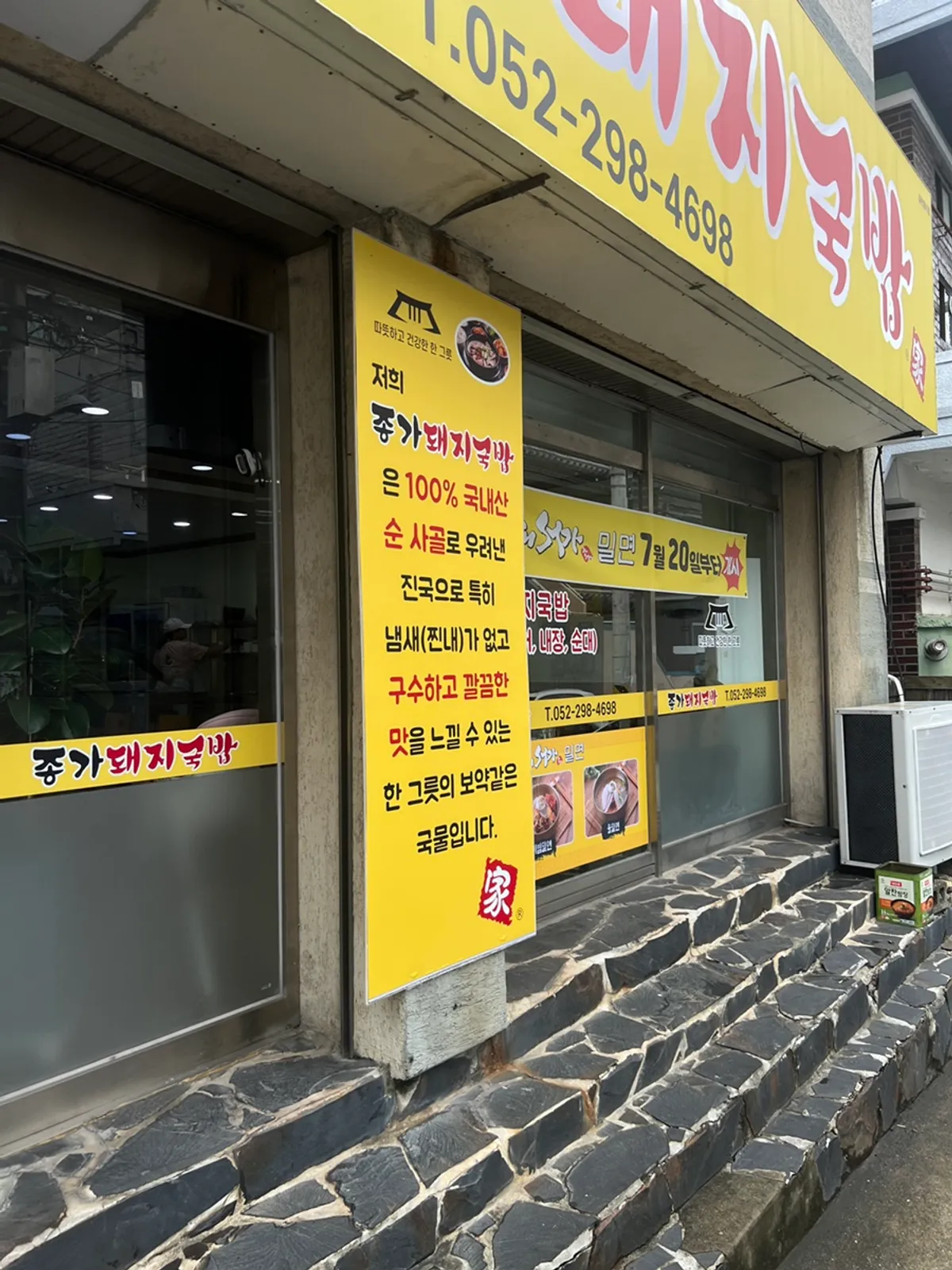 The yellow Jongga Dwaejigukbap sign visible right from the alley