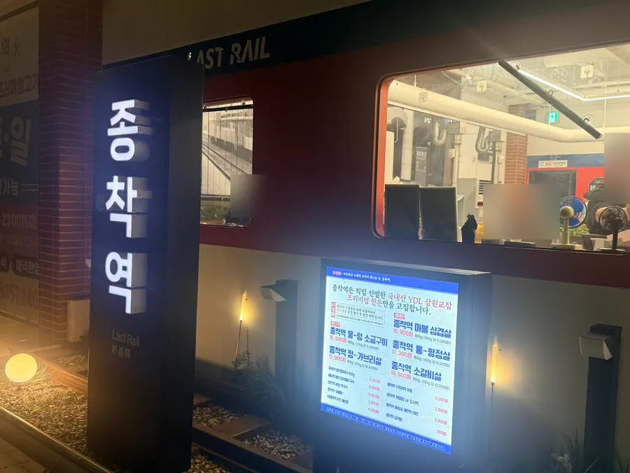 Train-station-style signage and props on the exterior of Jongchagyeok Gunsan Branch