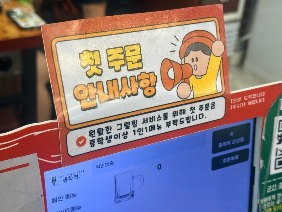 Sign explaining staff-grilled service and restaurant seating
