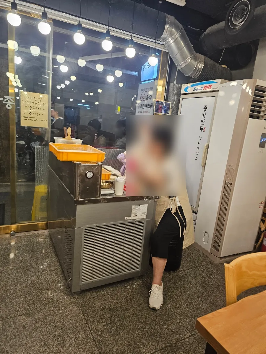 Dumplings being hand-pinched in front of the restaurant