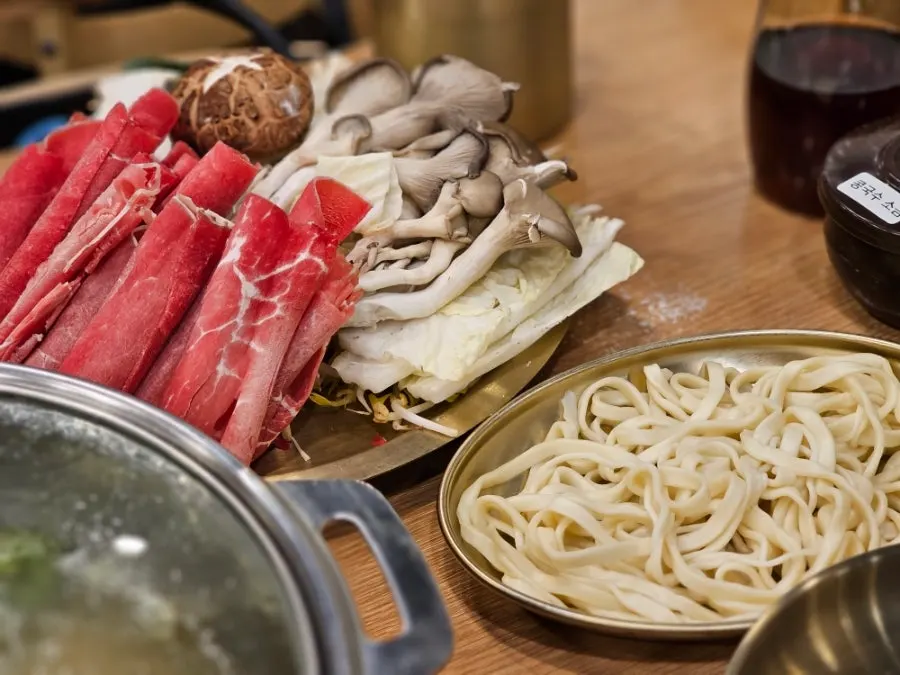 Vegetables, mushrooms, meat and kalguksu noodles laid out