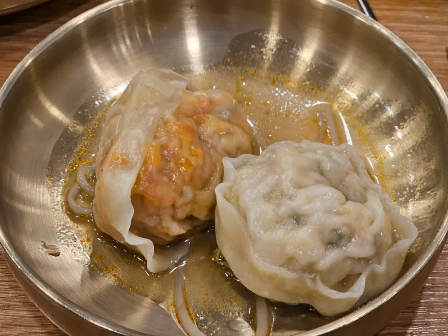 Handmade mandu and meat being eaten from the pot