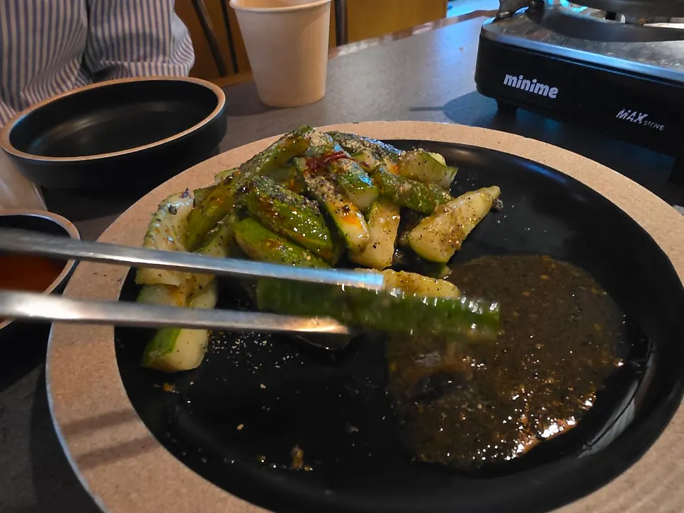Table spread with black sesame cucumber salad and perilla chicken hot pot