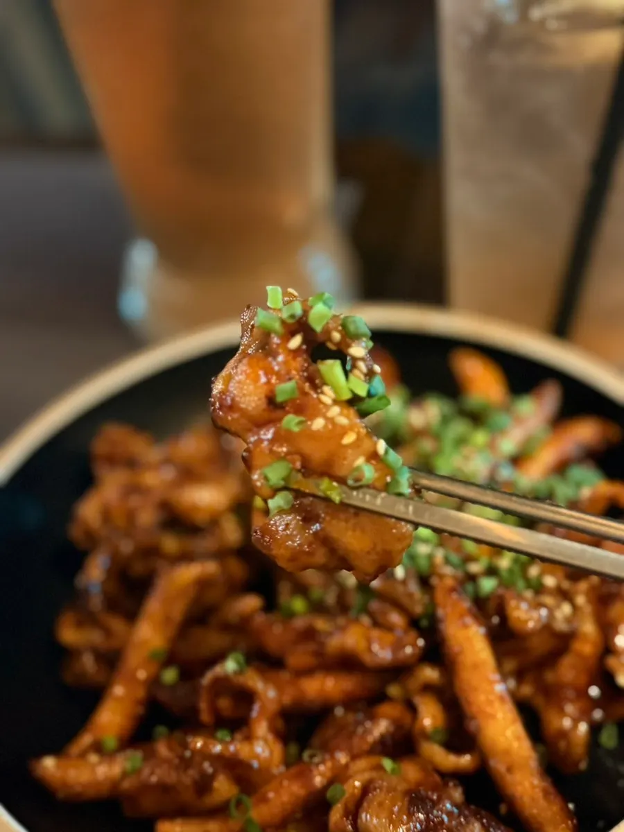 Close-up of smoky-charred chicken feet and rice cake