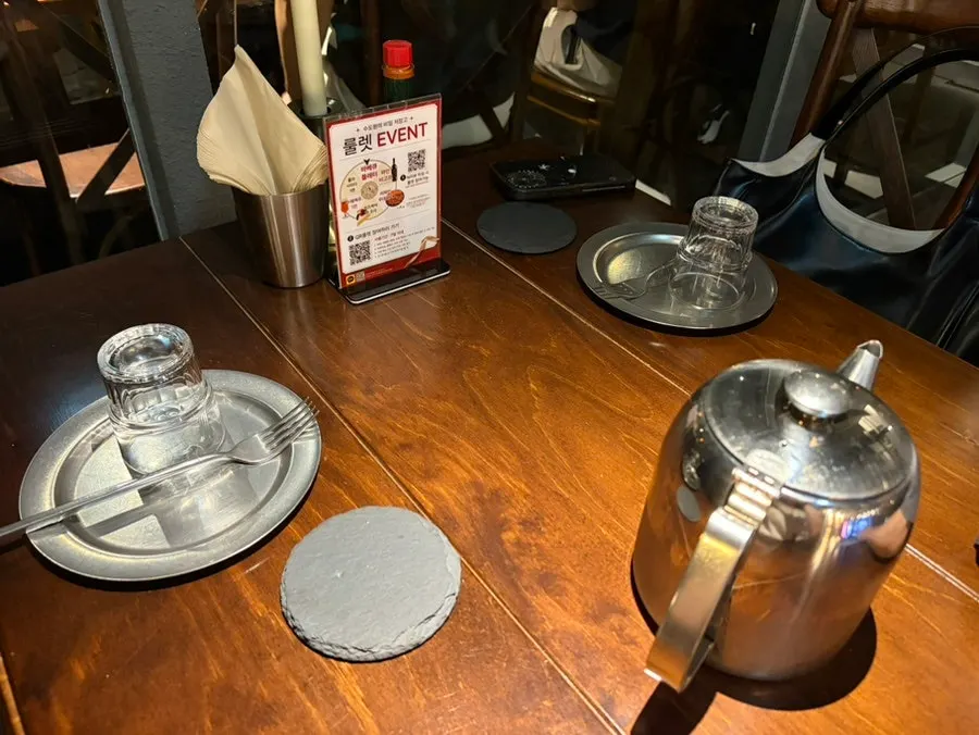Hall table set with cutlery, water, and Tabasco sauce