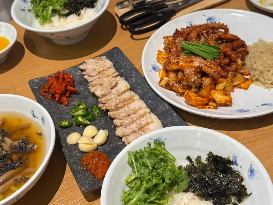 A bite of bossam topped with octopus as a three-way combo
