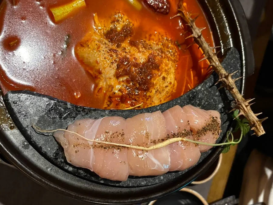 Table set with spicy hangover chicken hot pot and side dishes