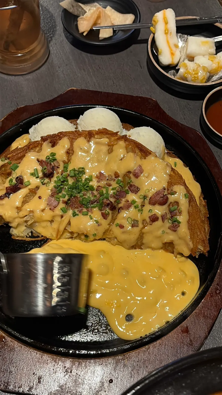 Staff pouring cheese over the potato pancake
