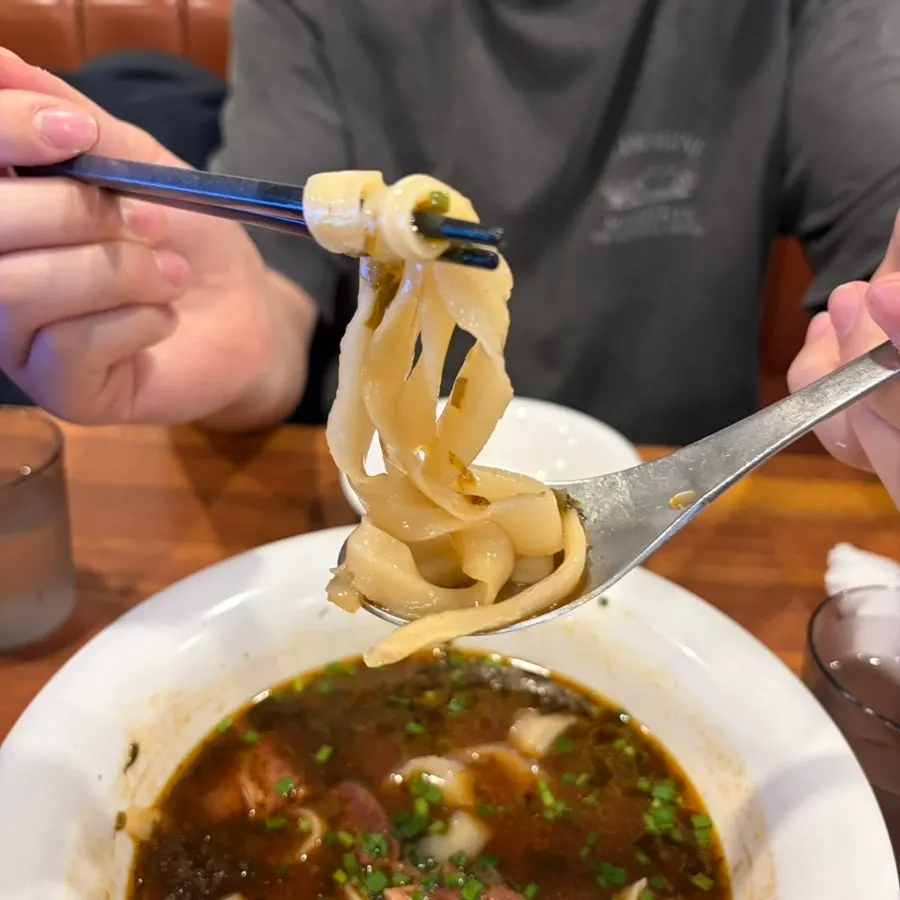 Chewy dosakmyeon noodles lifted with chopsticks