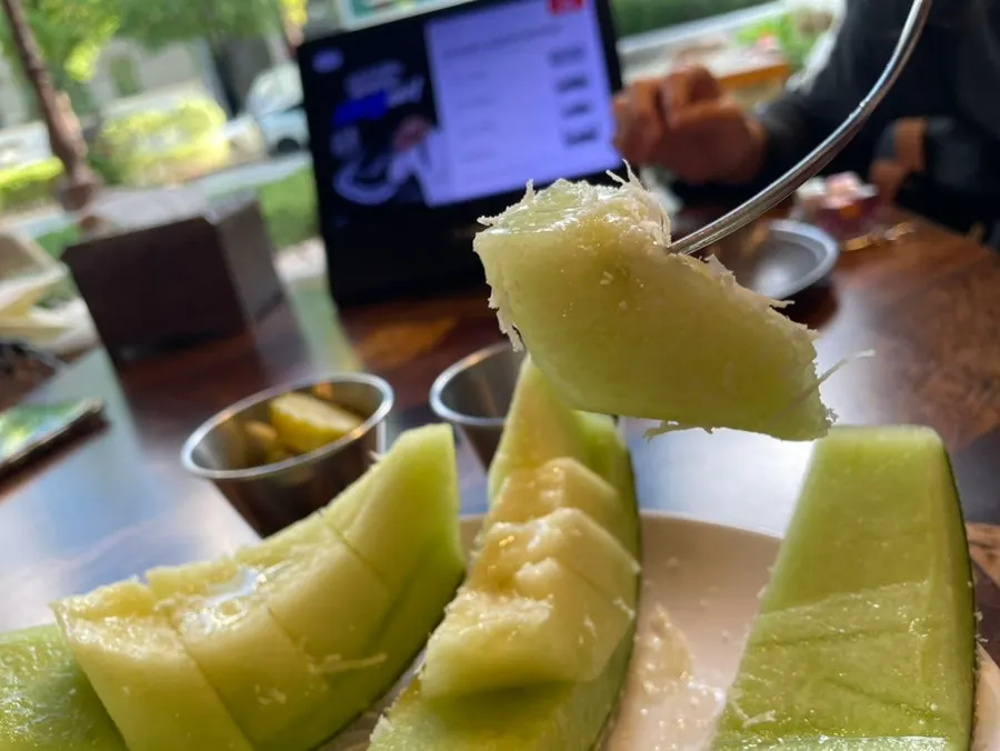 Half melon served alongside the pizza