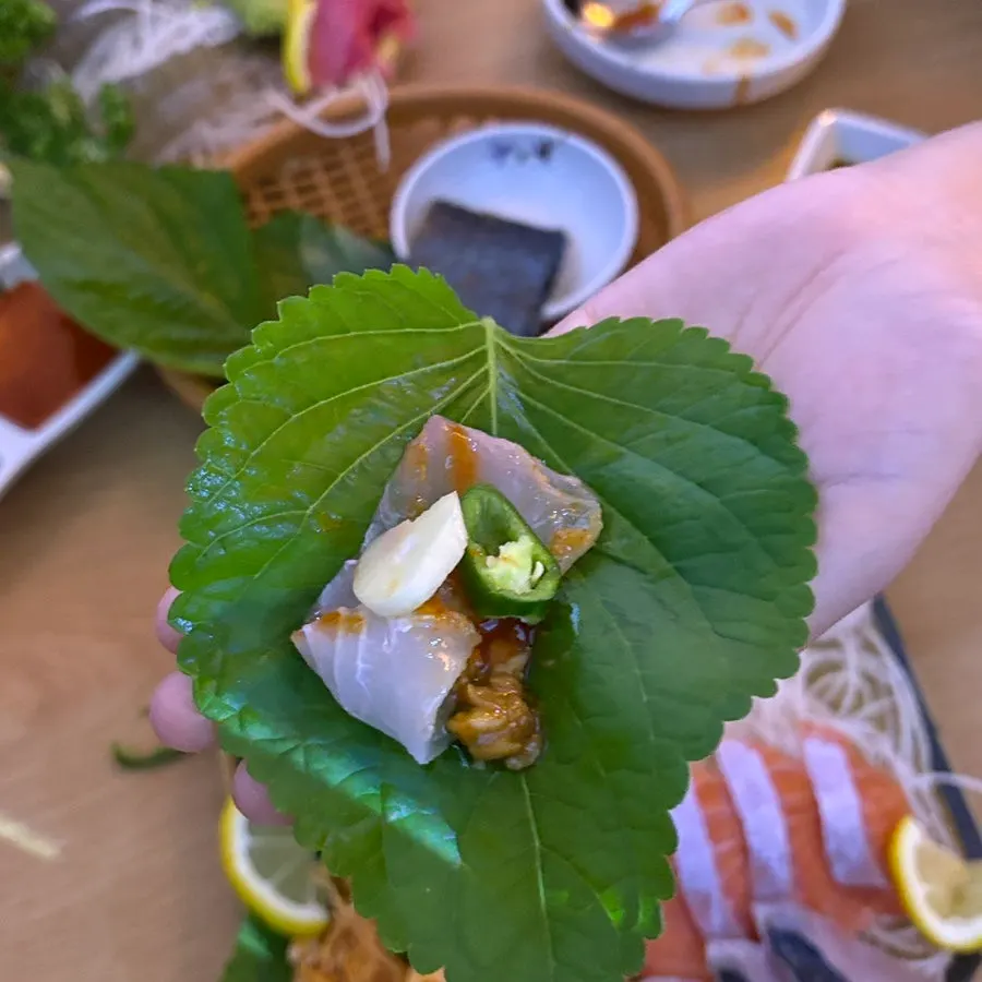 Perilla leaf wrap topped with sashimi, garlic and chili