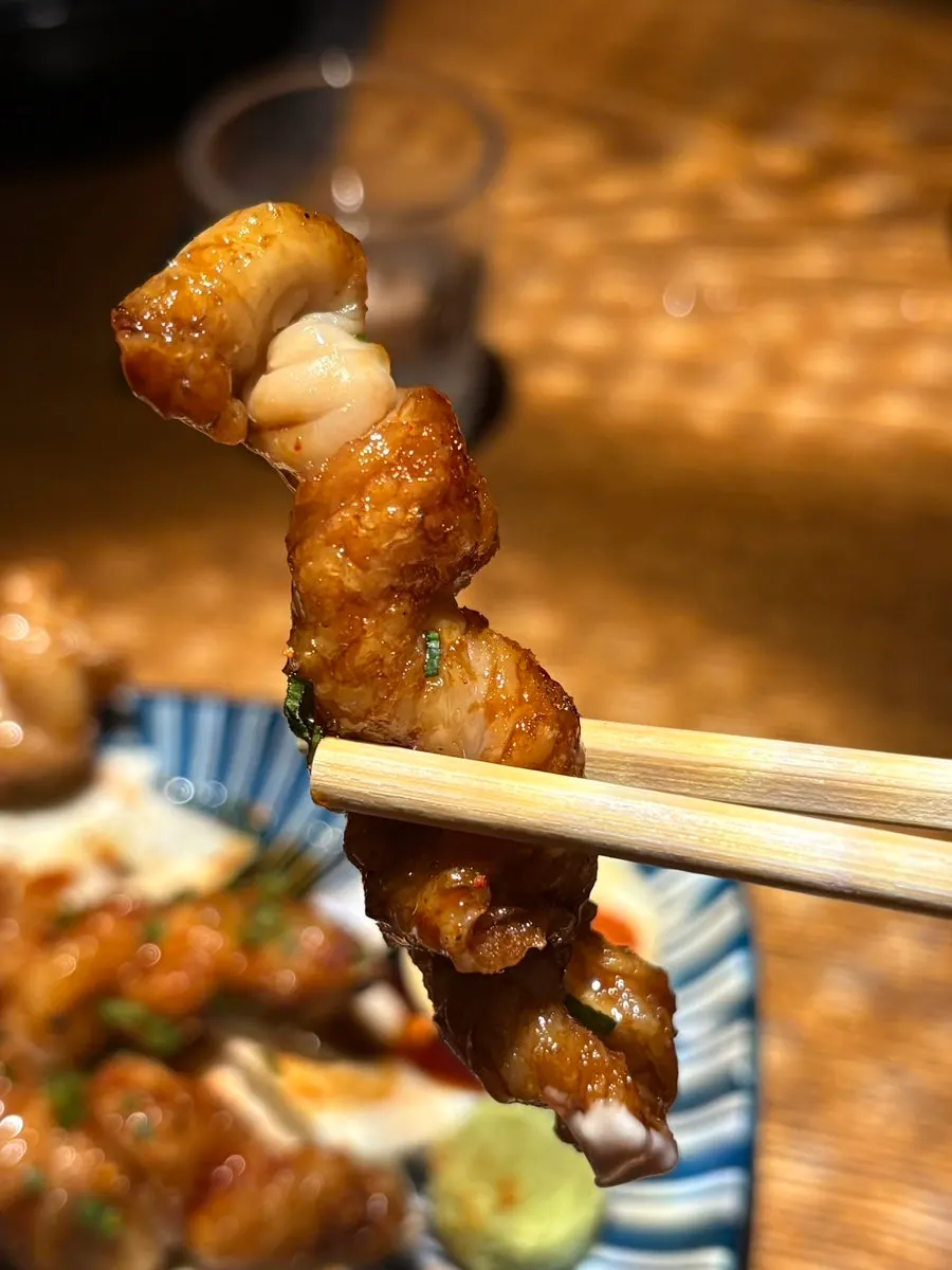 A plate of fried chicken skin sprinkled with shichimi