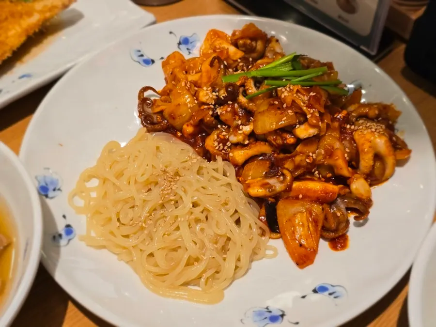 Spicy stir-fried baby octopus for two loaded with onion and cabbage