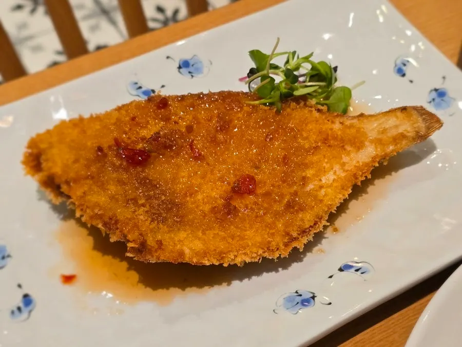A plate of whole flounder fritters topped with sauce