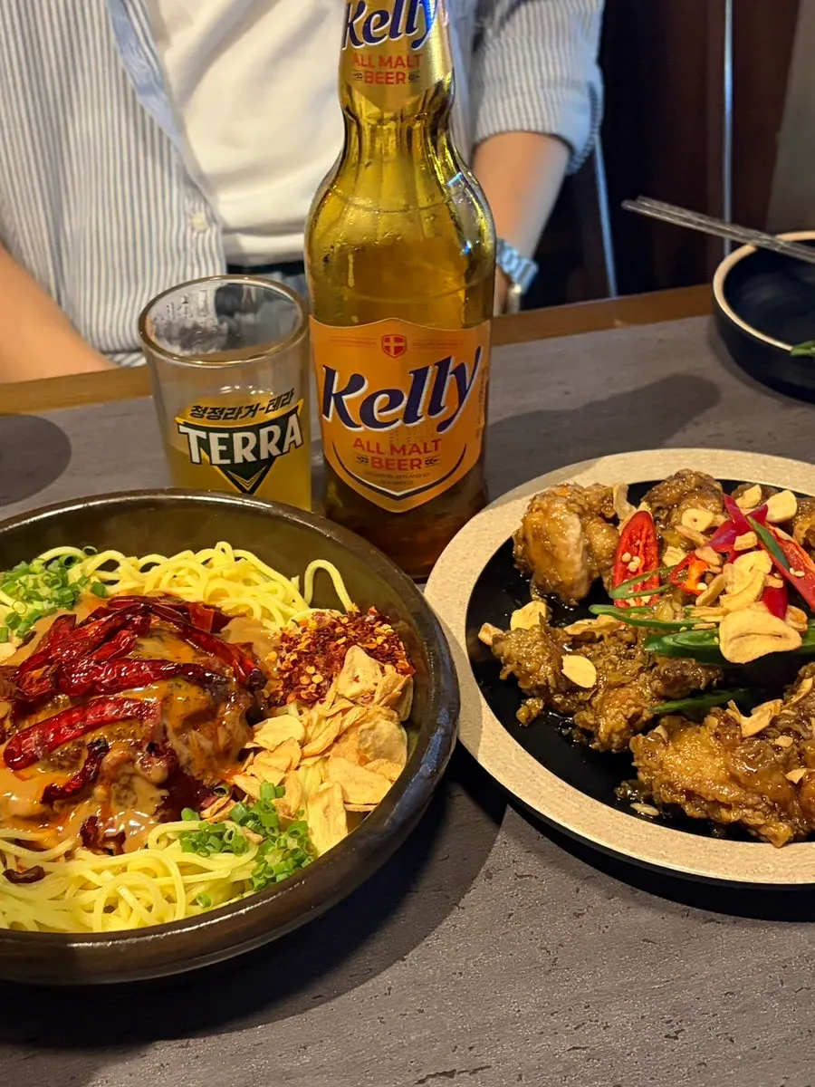 Table set with spicy tartare bibim noodles and black garlic fried chicken