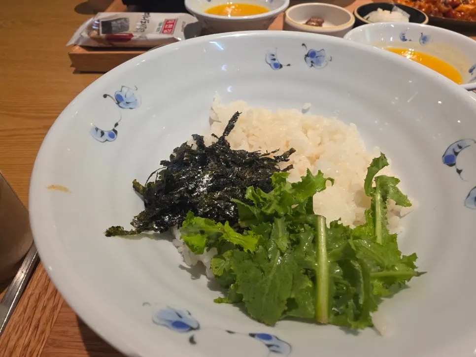 Bowl of rice, lettuce and seaweed flakes ready for mixing