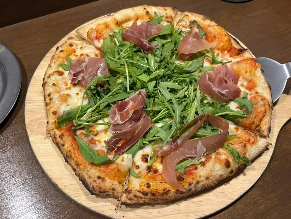 Table spread with pizza, dessert, and non-alcoholic beer
