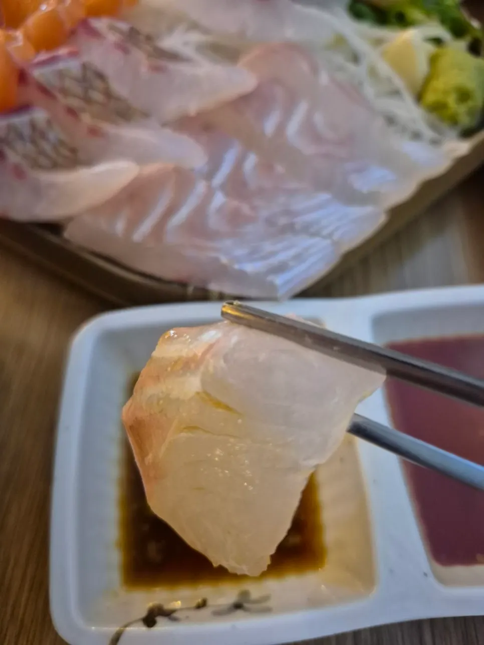 젓가락으로 집어 든 숙성회 한 점