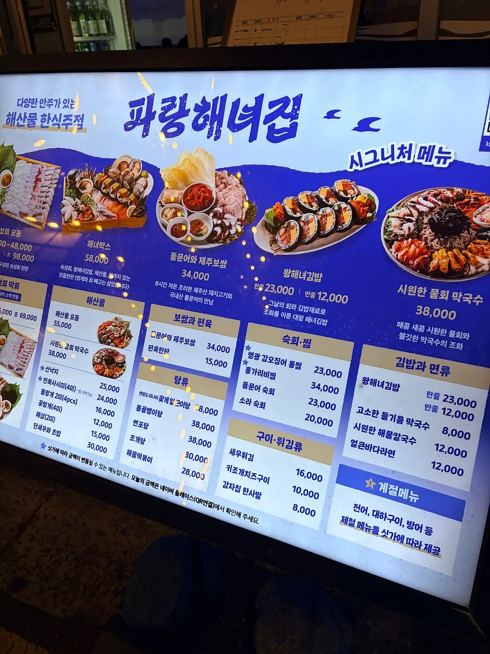 Menu board hanging in front of Parang Haenyeojip
