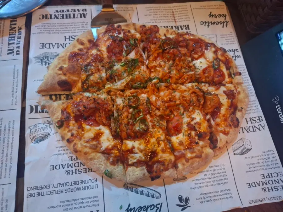 Handmade-dough Didi's Pizza topped with bacon and pepperoni