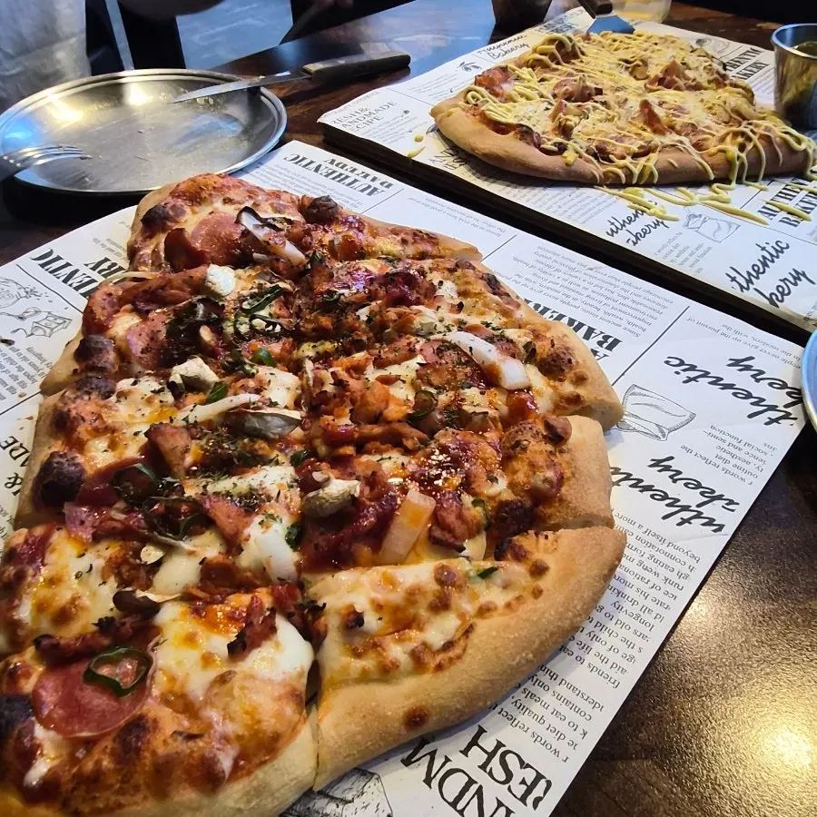 Two pizzas — fire chicken and classic — together on the table