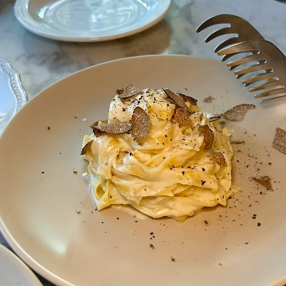 Finished truffle cheese wheel tagliatelle