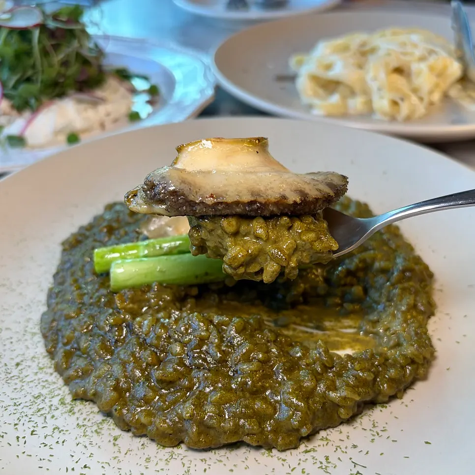 A spoonful of chewy barley risotto topped with sea mustard powder