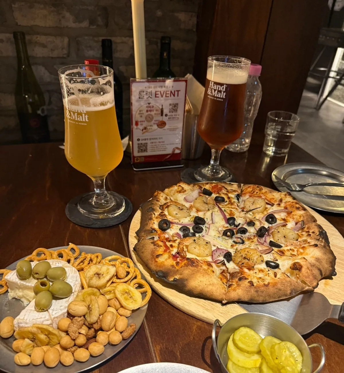 A full pizza-and-beer spread at Sudowonui Bimil Jeojanggo