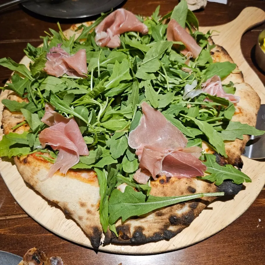 A slice of the Monastery Garden arugula jambon pizza
