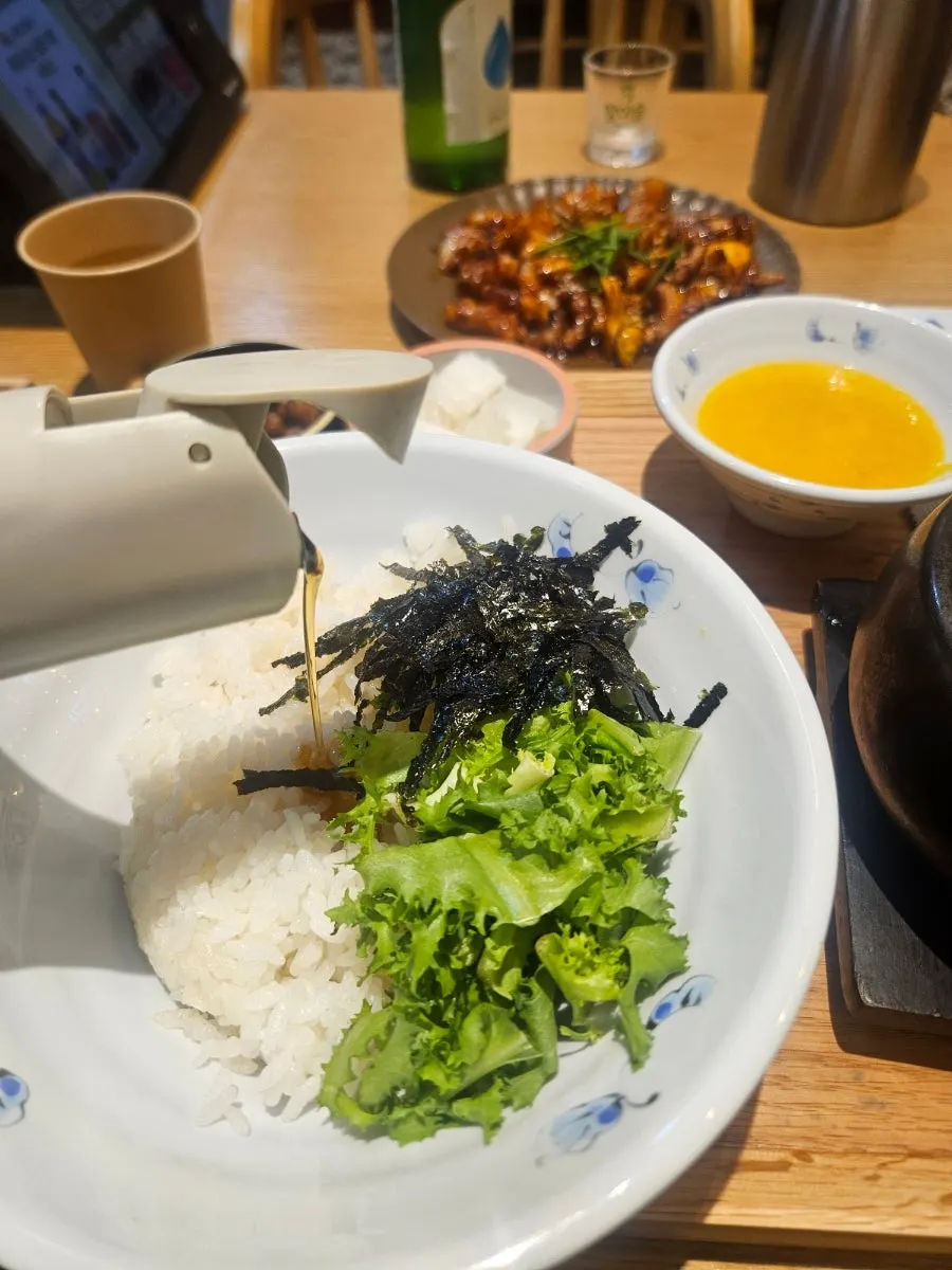 비빔밥 위에 참기름을 두르는 장면