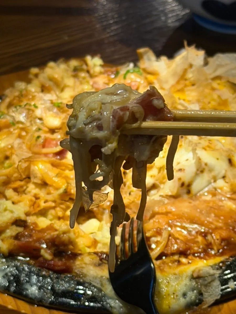 Okonomiyaki topped with bacon and assorted toppings