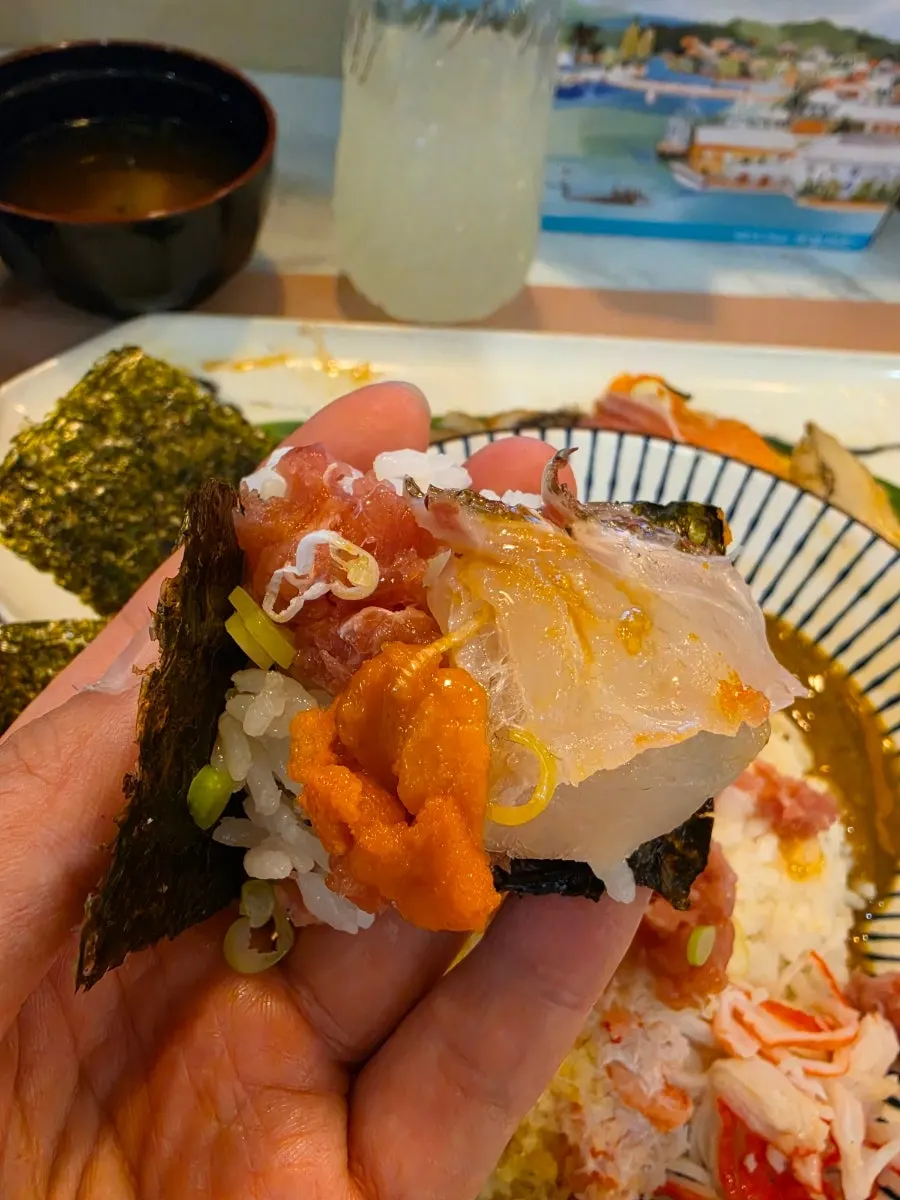 A bite of rice and sashimi wrapped in seaweed