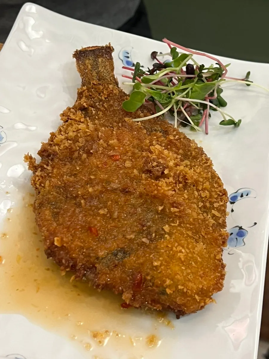 Crispy whole fried flounder topped with sauce