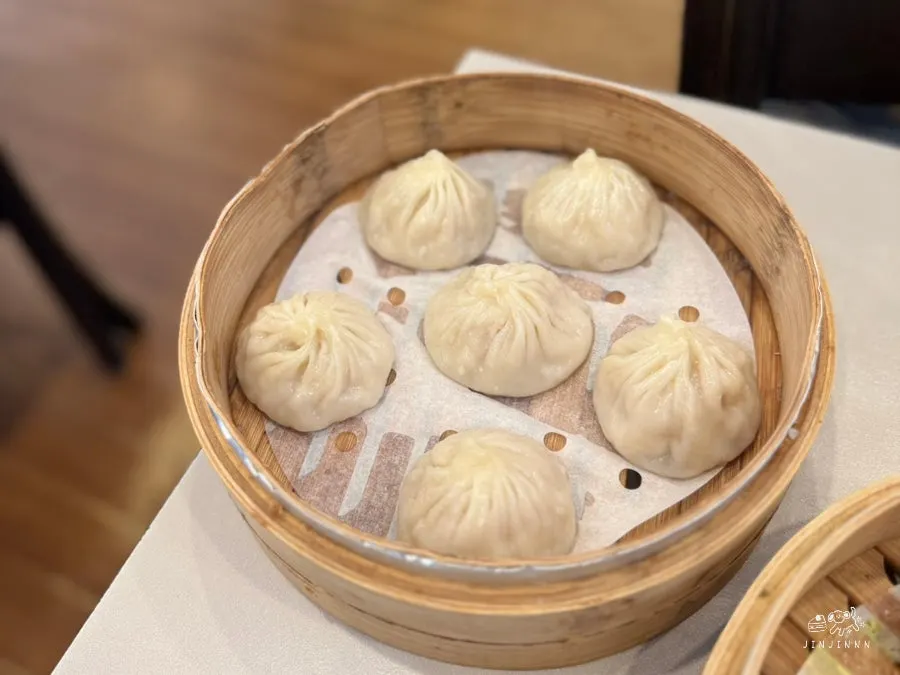 A plate of xiaolongbao dim sum filled with broth