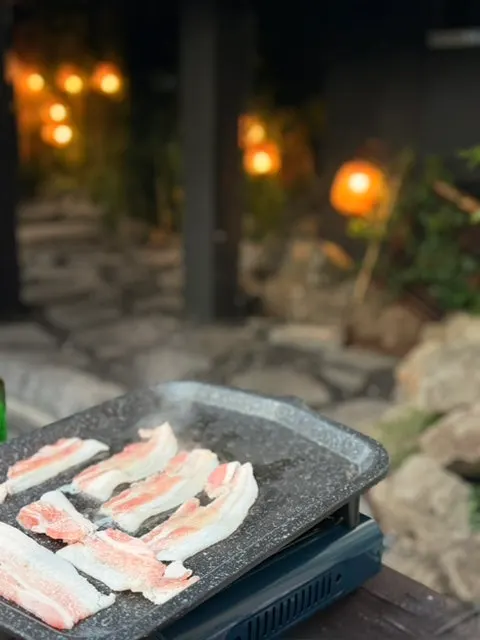 달궈진 불판에 펼쳐 올린 냉동삼겹살