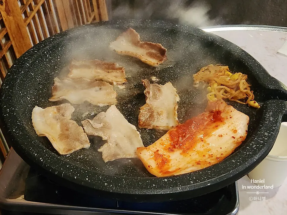 Frozen pork belly placed on the round stone grill plate