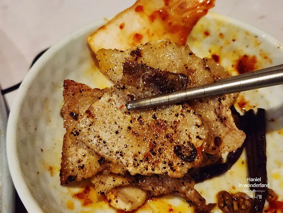 Frozen pork belly grilled with a heavy dusting of ground black pepper