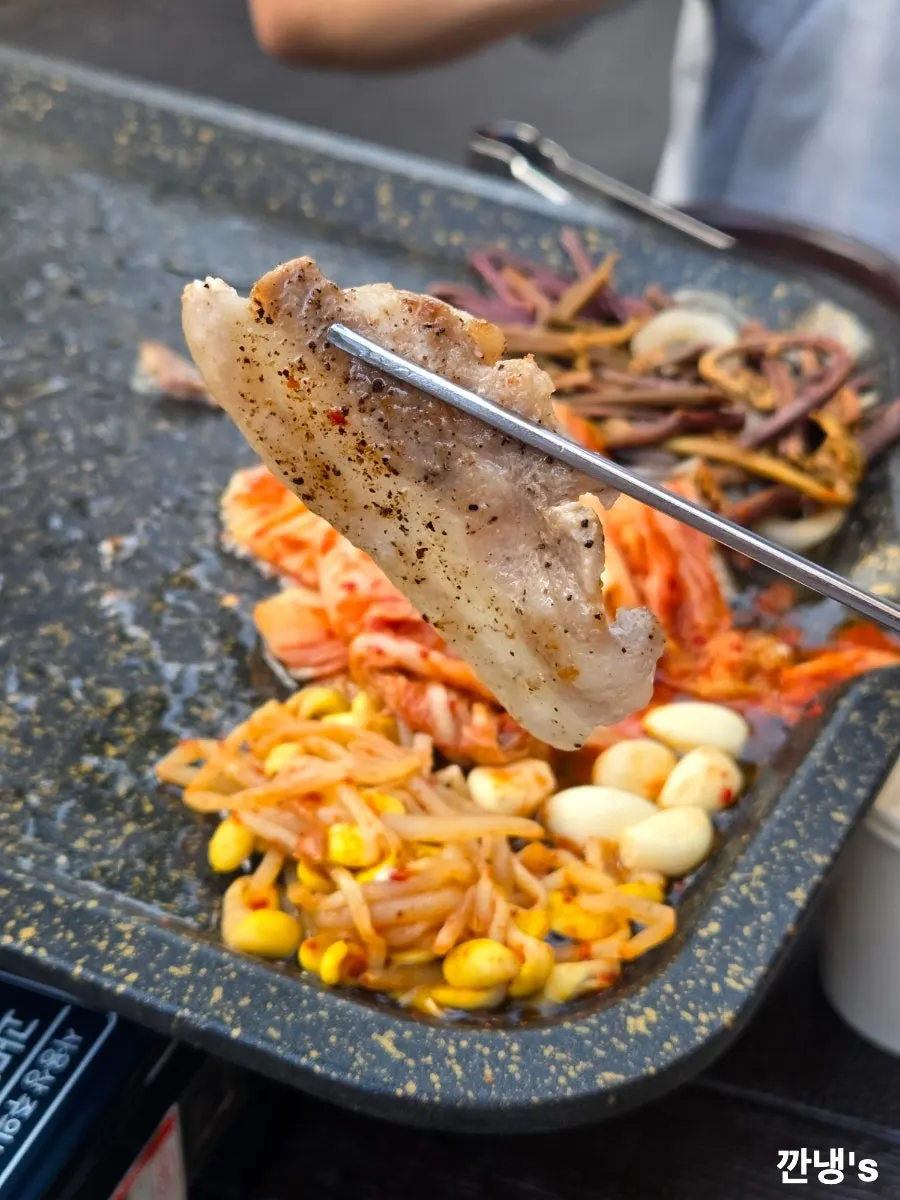 야외 테이블에 놓인 소주잔과 고기