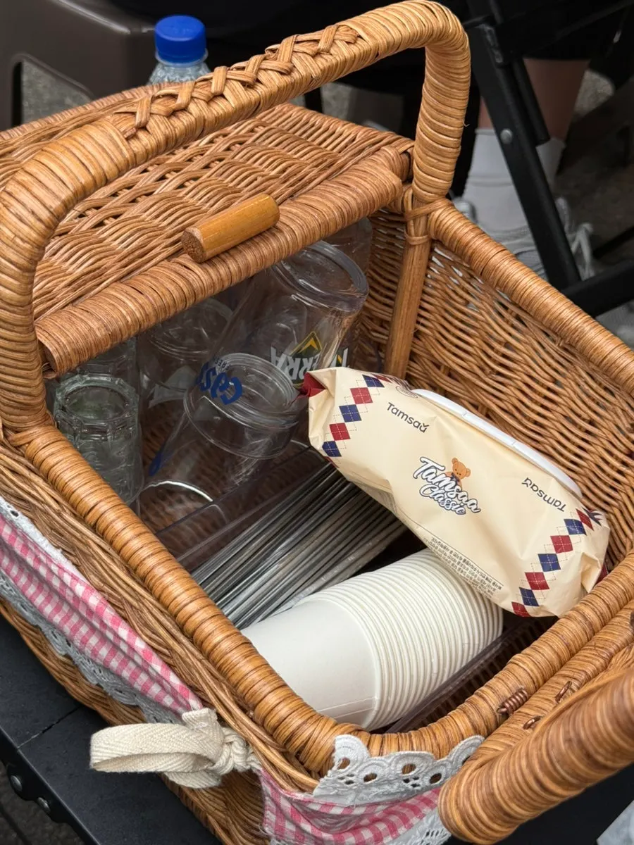 Picnic-basket utensil set between tables