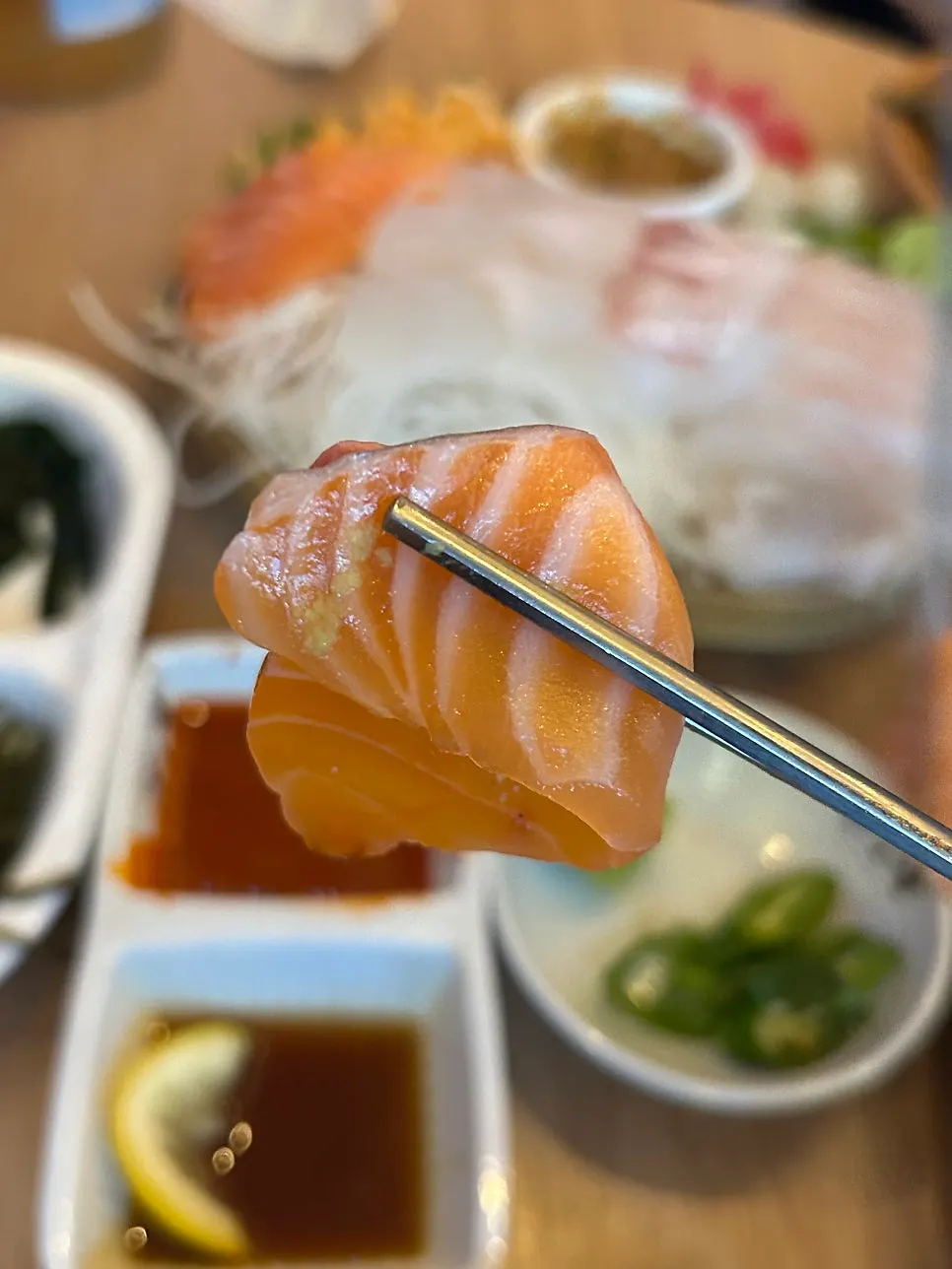 A piece of aged sashimi picked up with chopsticks