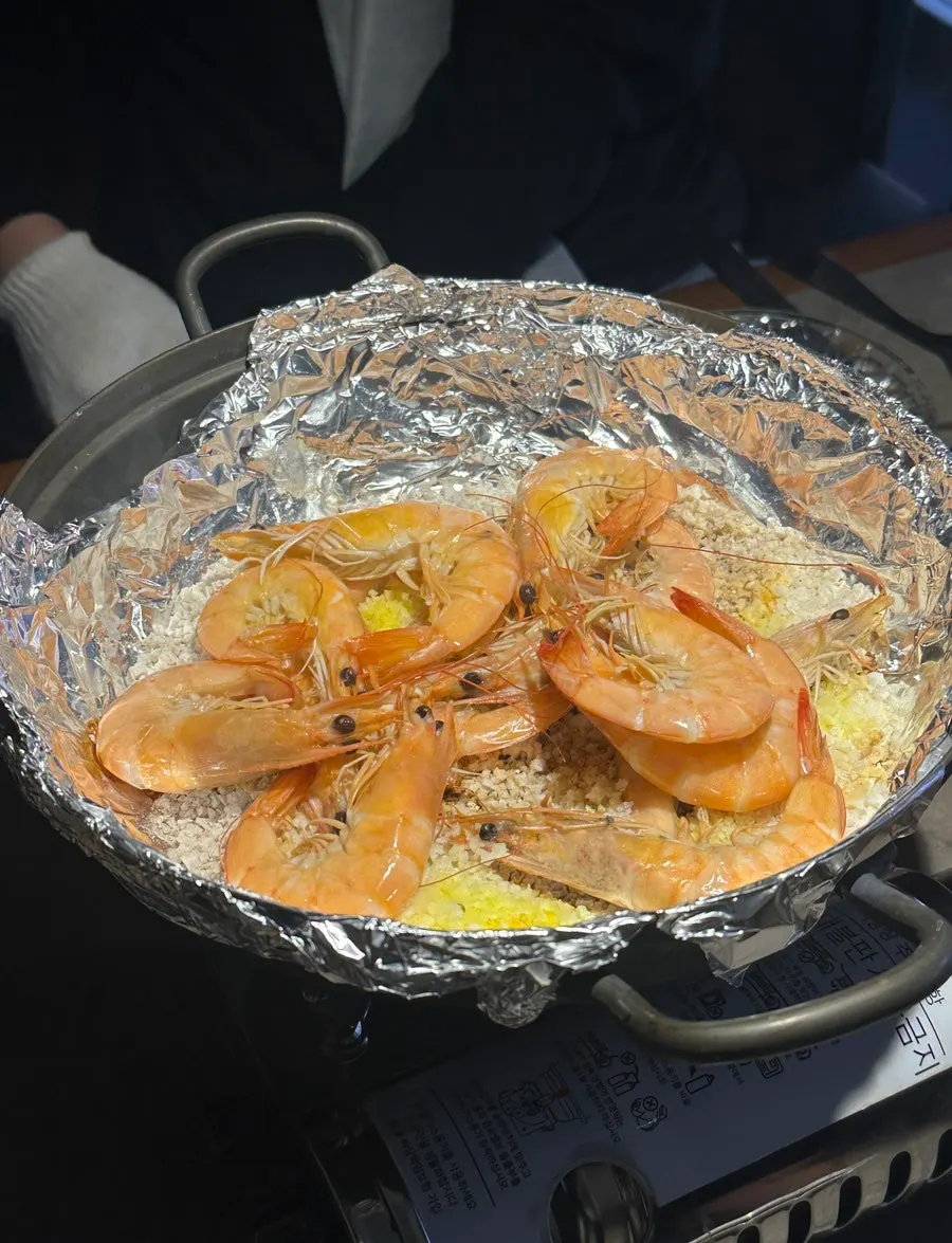 Salt-grilled shrimp cooking on a bed of salt