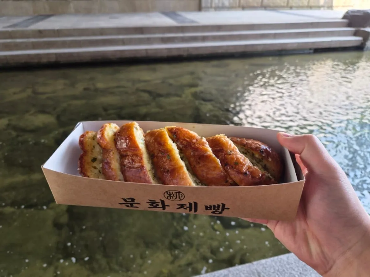 Garlic bread and bagel set on a bench by Cheonggyecheon