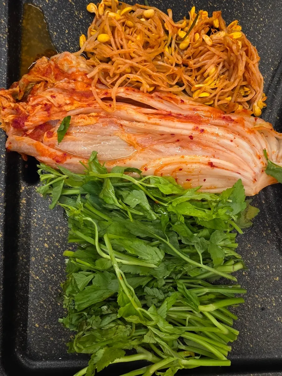 Whole-leaf kimchi grilling in the center of the pan