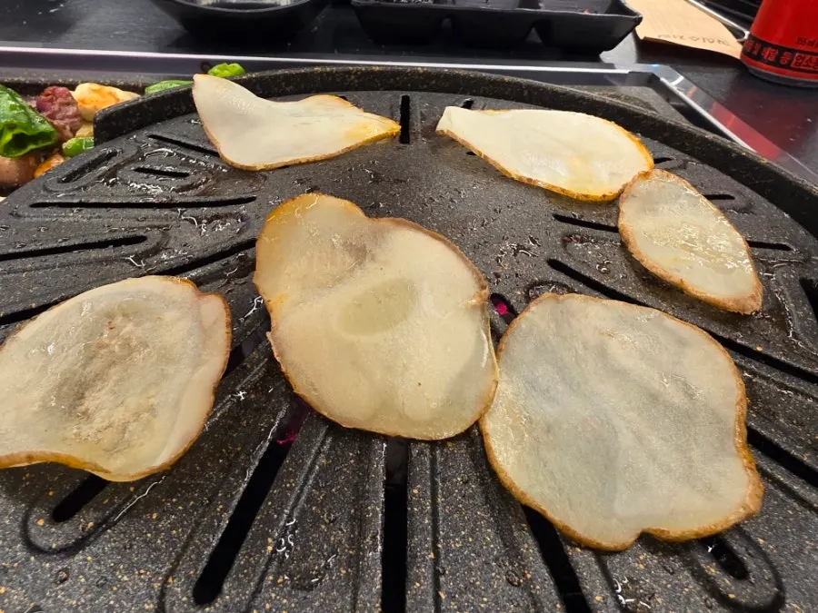 Grilled pork belly moved over to the vegetable side of the pan